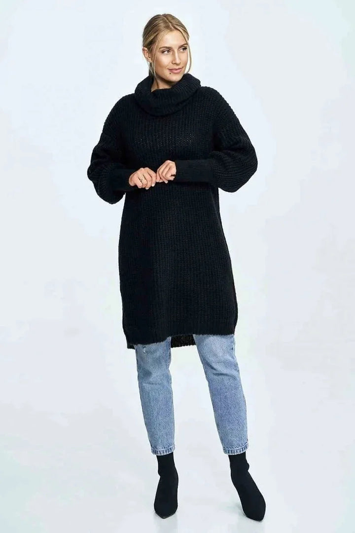 Black chunky knit turtleneck sweater dress with light wash distressed jeans and black sock boots on model.