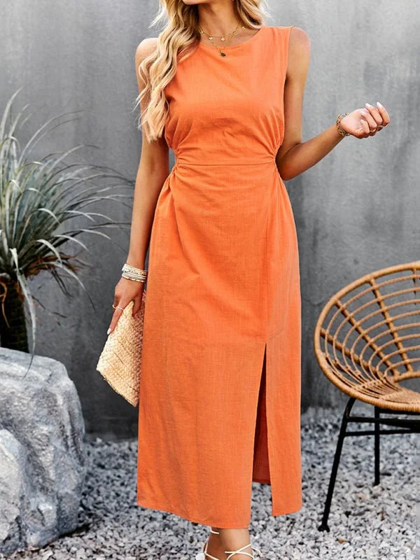 Orange linen-blend midi dress with a side slit, worn by a model holding a straw clutch.