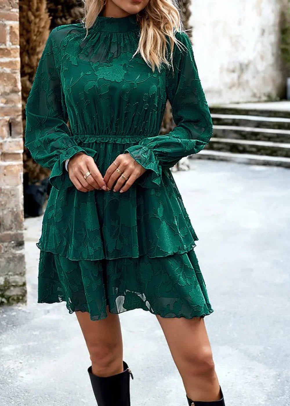 Emerald green tiered dress with floral burnout texture and ruffled sleeves on model.