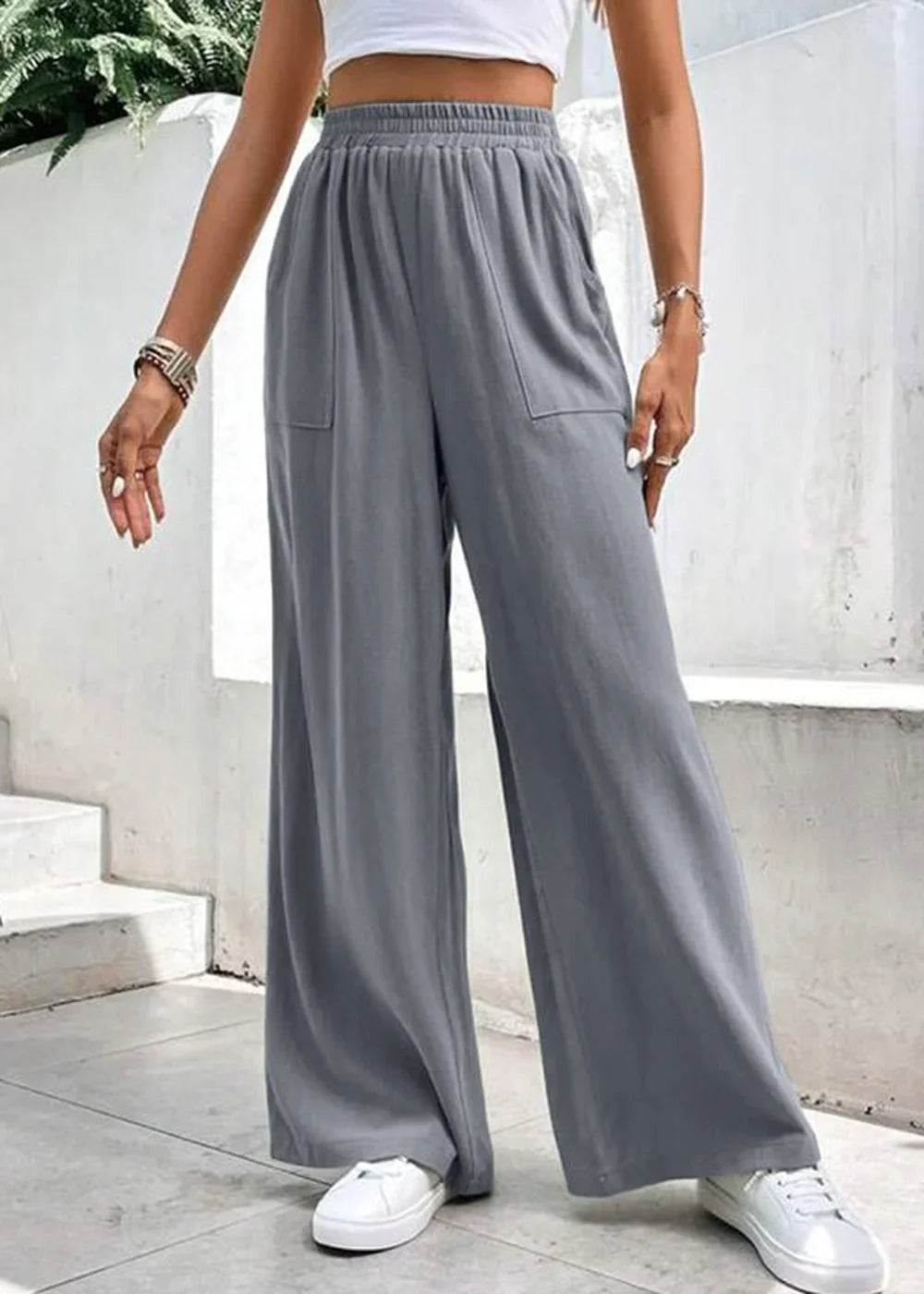 Gray wide-leg pants with pockets and elastic waistband on a model.