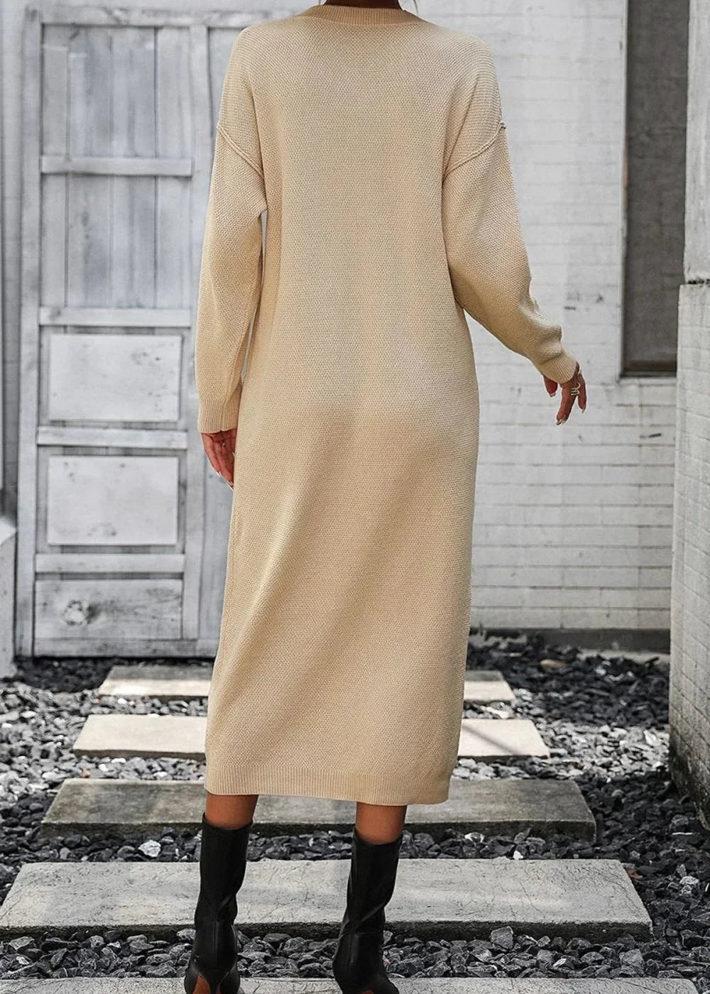 Back view of a beige knit sweater dress with long sleeves, shown on a model with black boots.