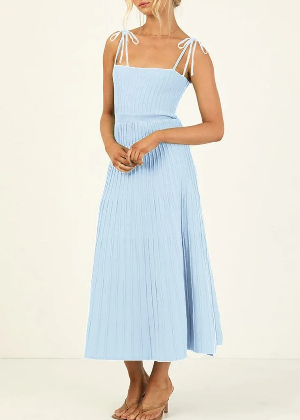 Light blue ribbed knit midi dress with tie-shoulder straps and a pleated skirt, on model.