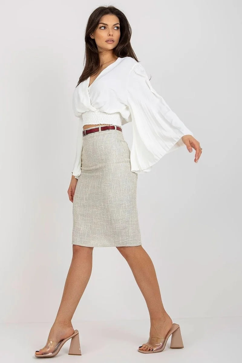 Model in white v-neck blouse with bell sleeves and a textured beige pencil skirt with a red belt.