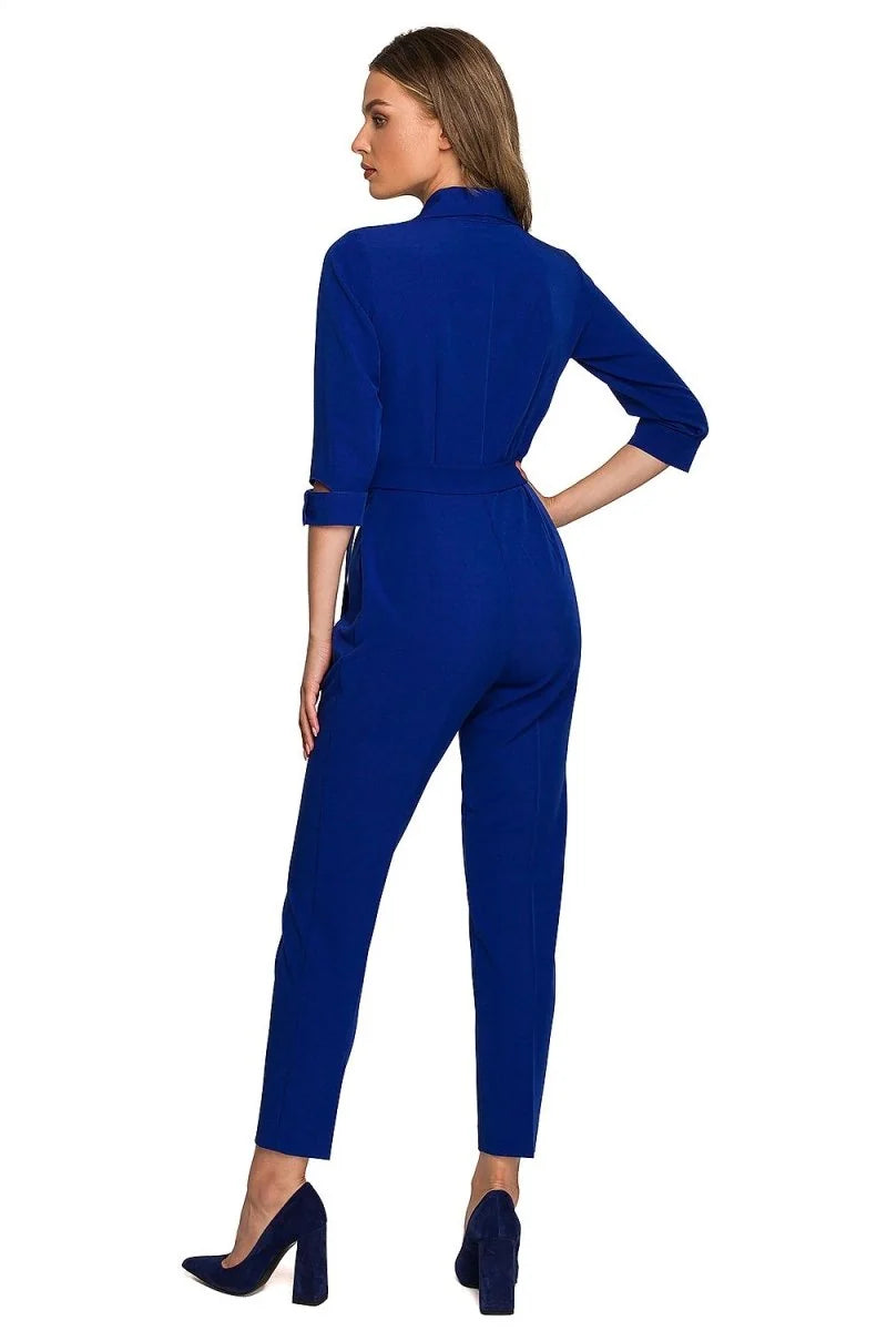 Royal blue jumpsuit with a belted waist and three-quarter sleeves, shown from the back on a model.