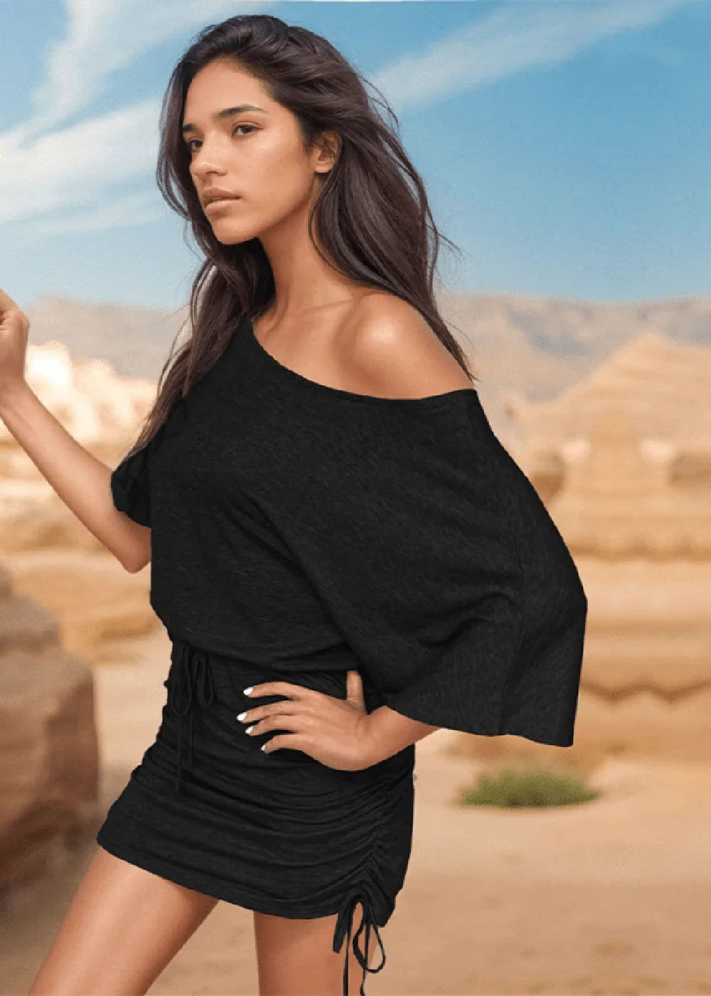 Black off-the-shoulder ruched mini dress with drawstring detail, on model in desert landscape.
