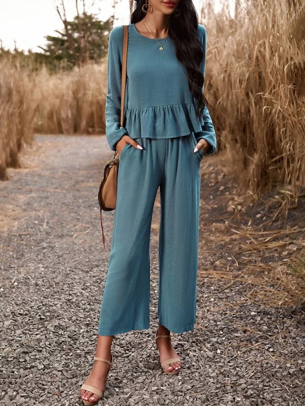 Teal linen blend pantsuit with ruffle detail and sandals on model.