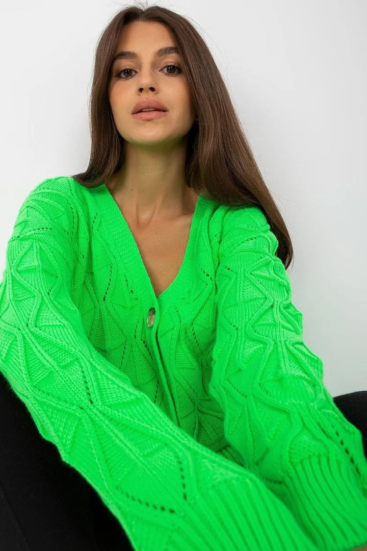 Close-up of a neon green knit cardigan with a diamond pattern and a single button closure.