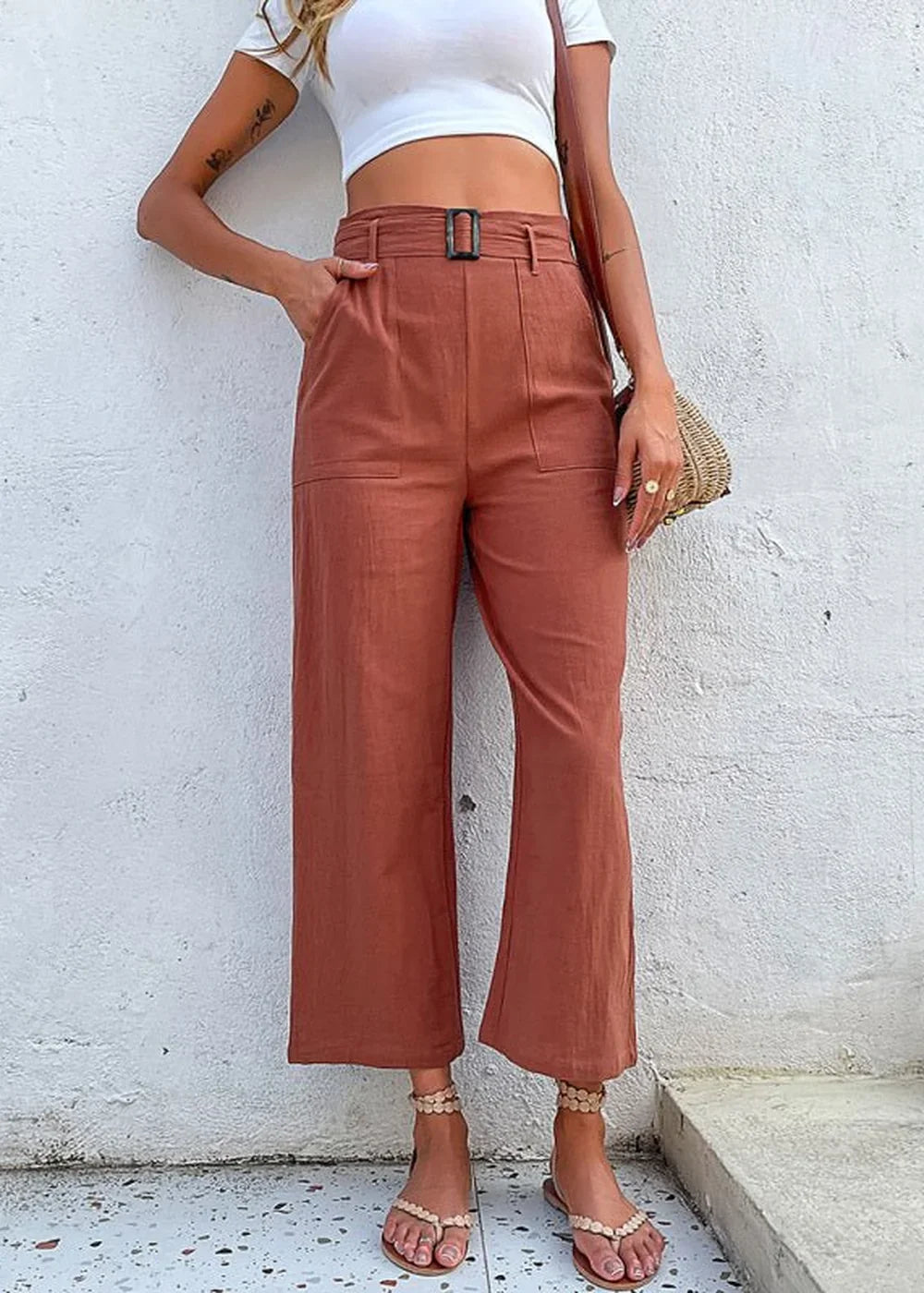 Rust colored, wide-leg, 100% cotton cropped pants with a belted waist and pockets on model.