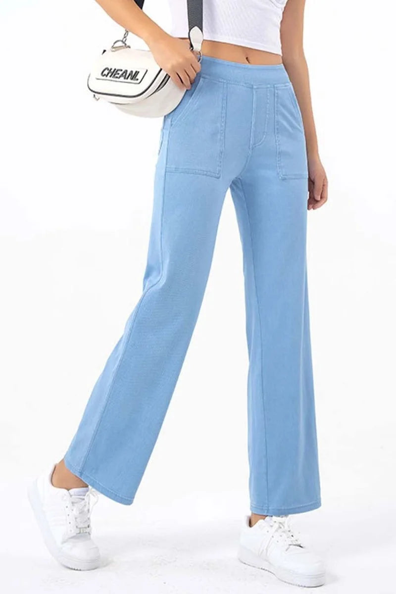 Light blue wide-leg pants with contrast stitching and front pockets, on a model wearing white sneakers.