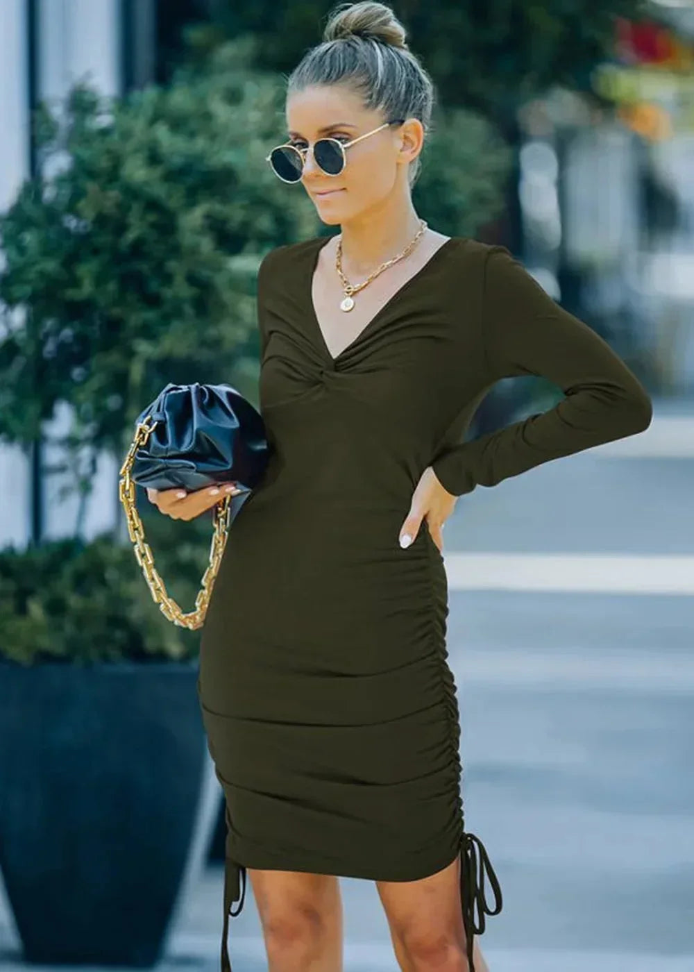 Olive green ruched mini dress with V-neck and drawstring hem, worn by a model.