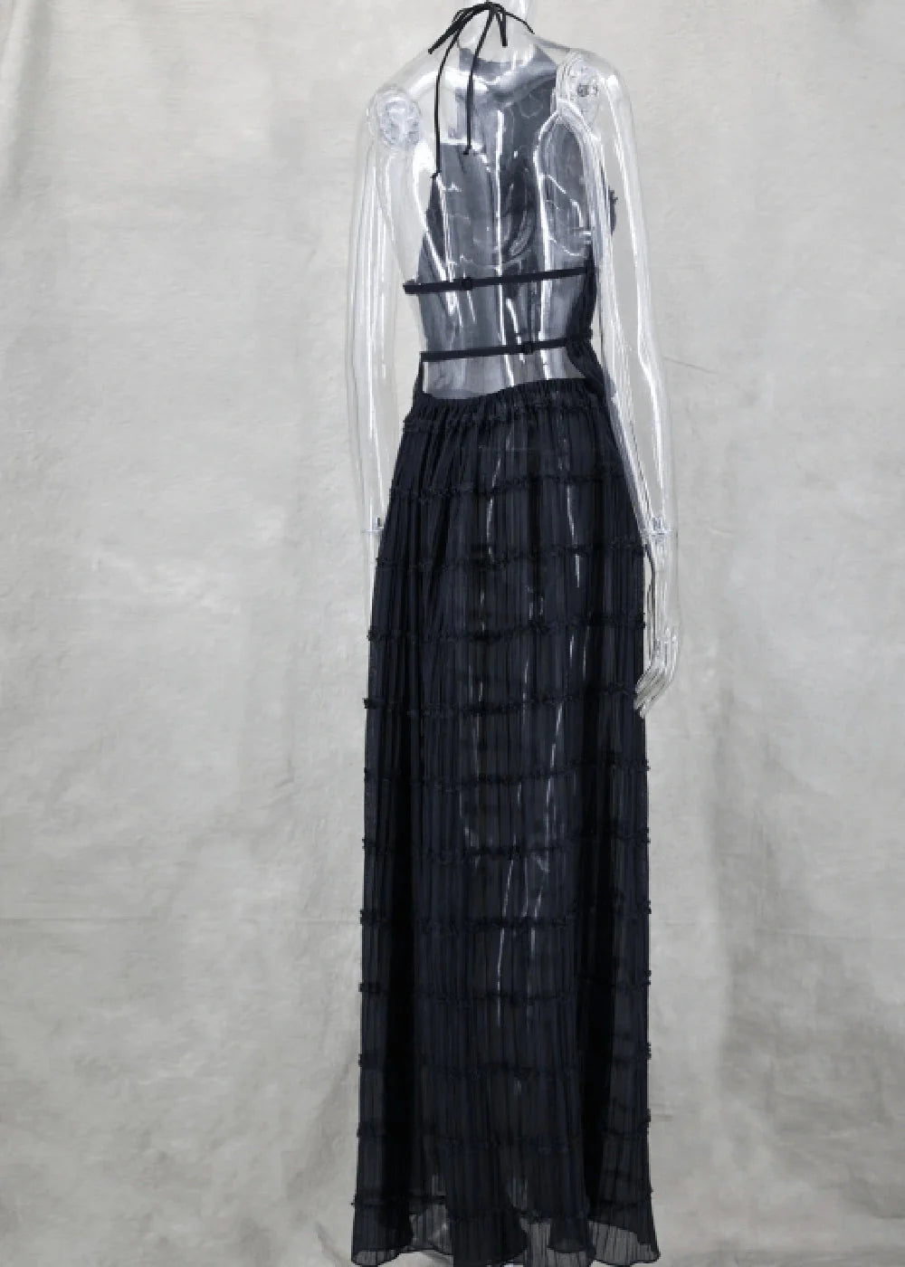 Black halter neck maxi dress with sheer, tiered skirt and intricate back straps.