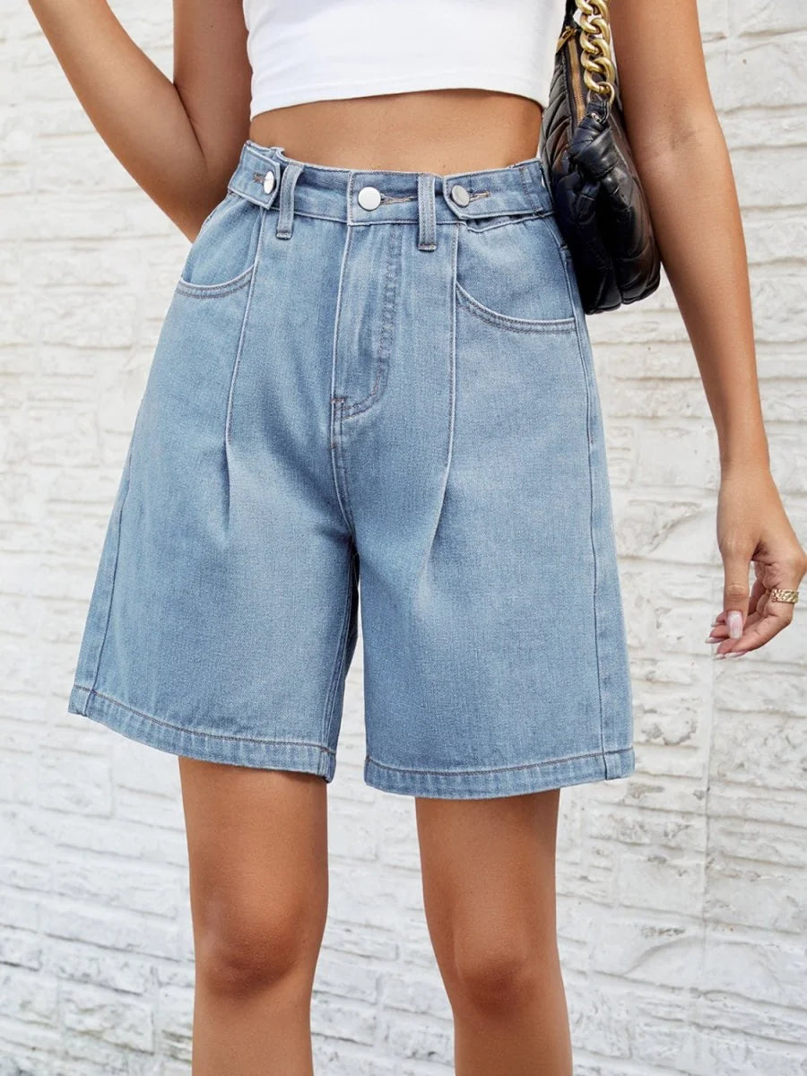 Light blue denim shorts with pleats and a relaxed fit, worn by a model.