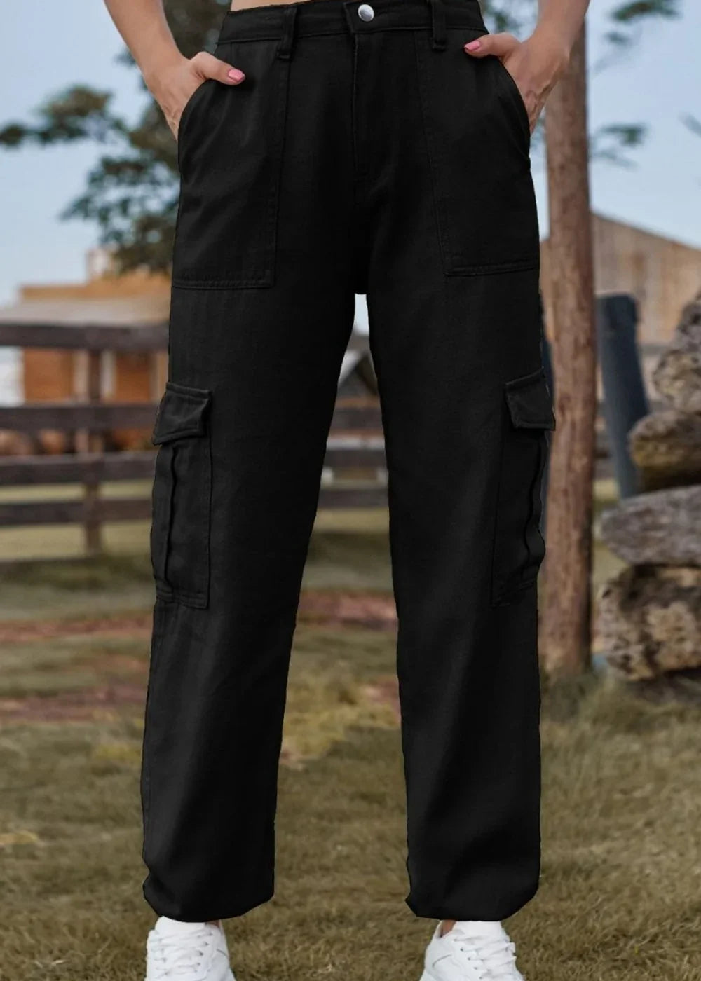 Black cargo pants with multiple pockets, shown on a model wearing white sneakers.