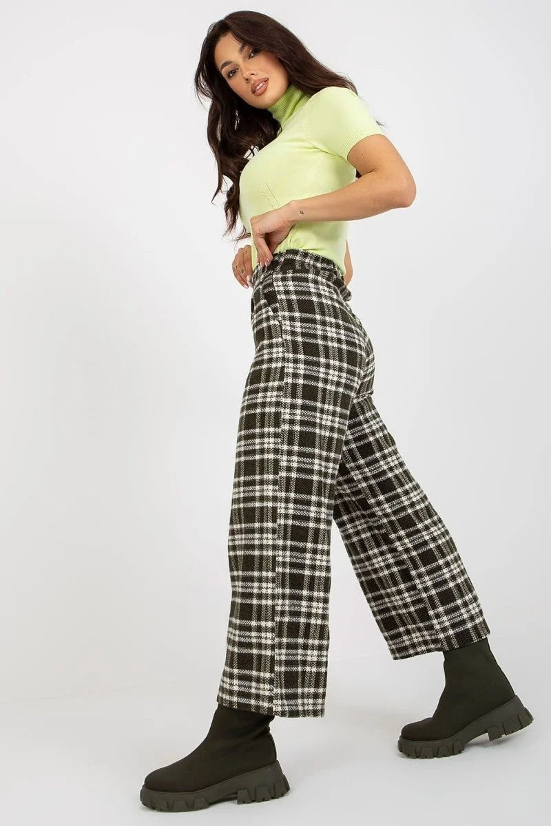 Dark green and white checkered wool pants with a wide leg and thick-soled boots.