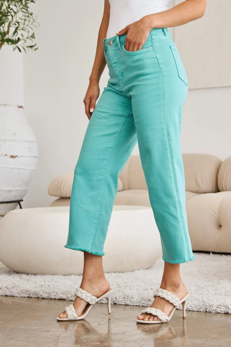 Aqua cropped jeans with frayed hem and moderate stretch, shown on a model.