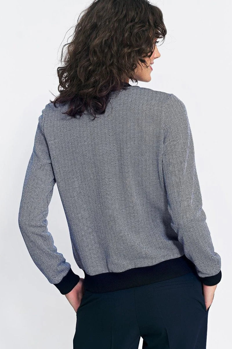 Loose-fit bomber jacket with a navy and white herringbone pattern and black cuffs.