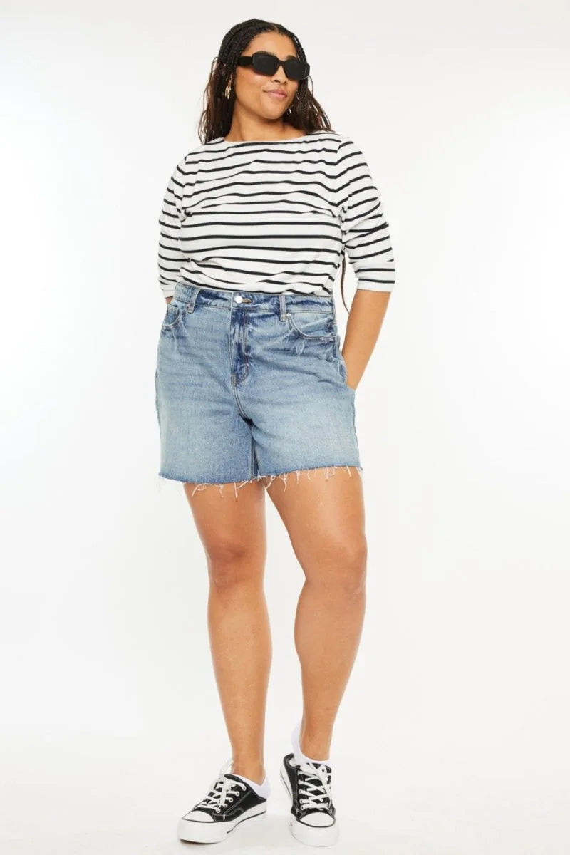 Light wash denim shorts with frayed hem, on a model.