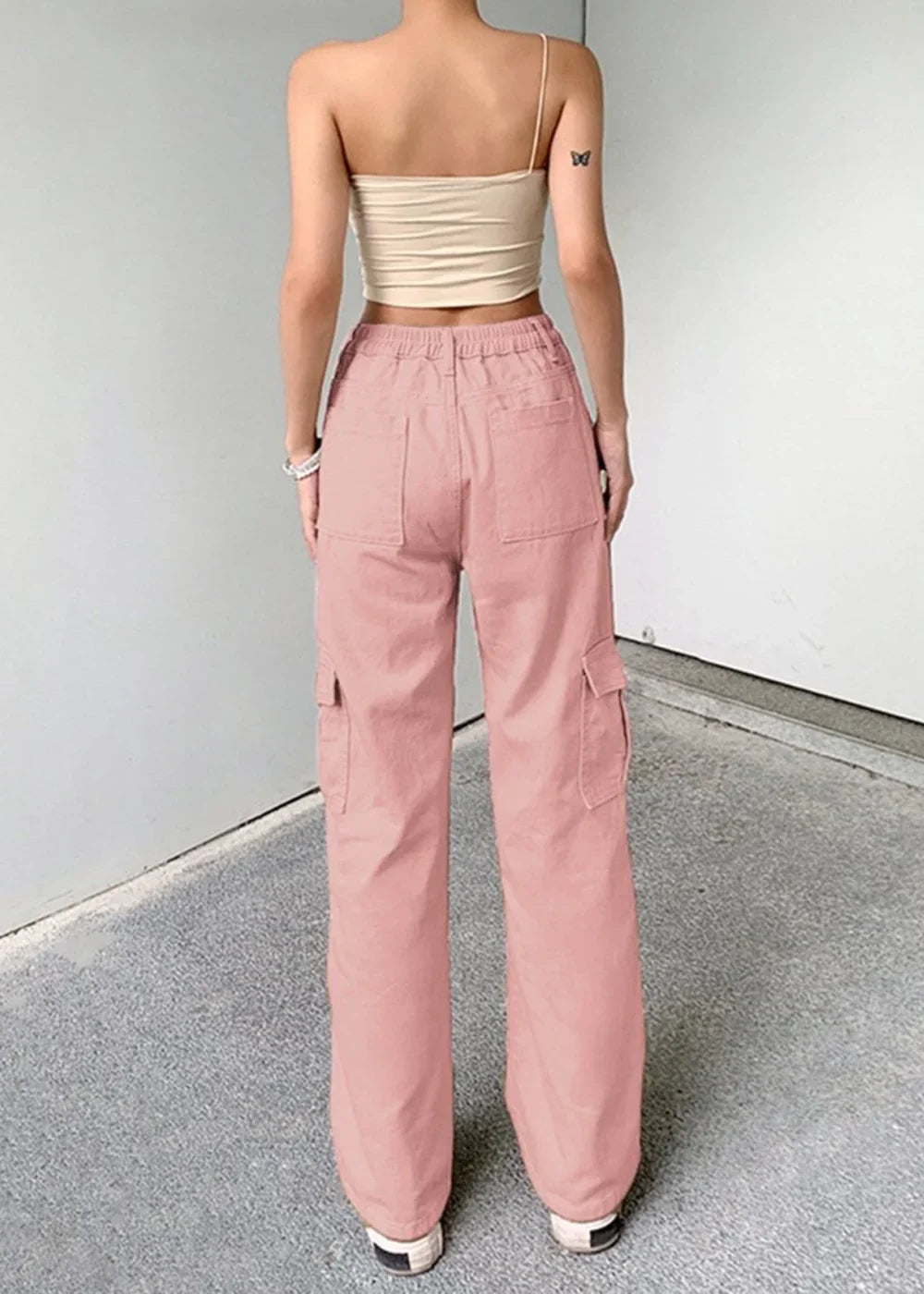 Pink cargo pants with a relaxed fit and utility pockets on a model.