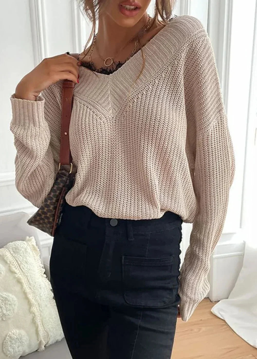 Cream knit sweater with black lace trim and a crossbody bag.