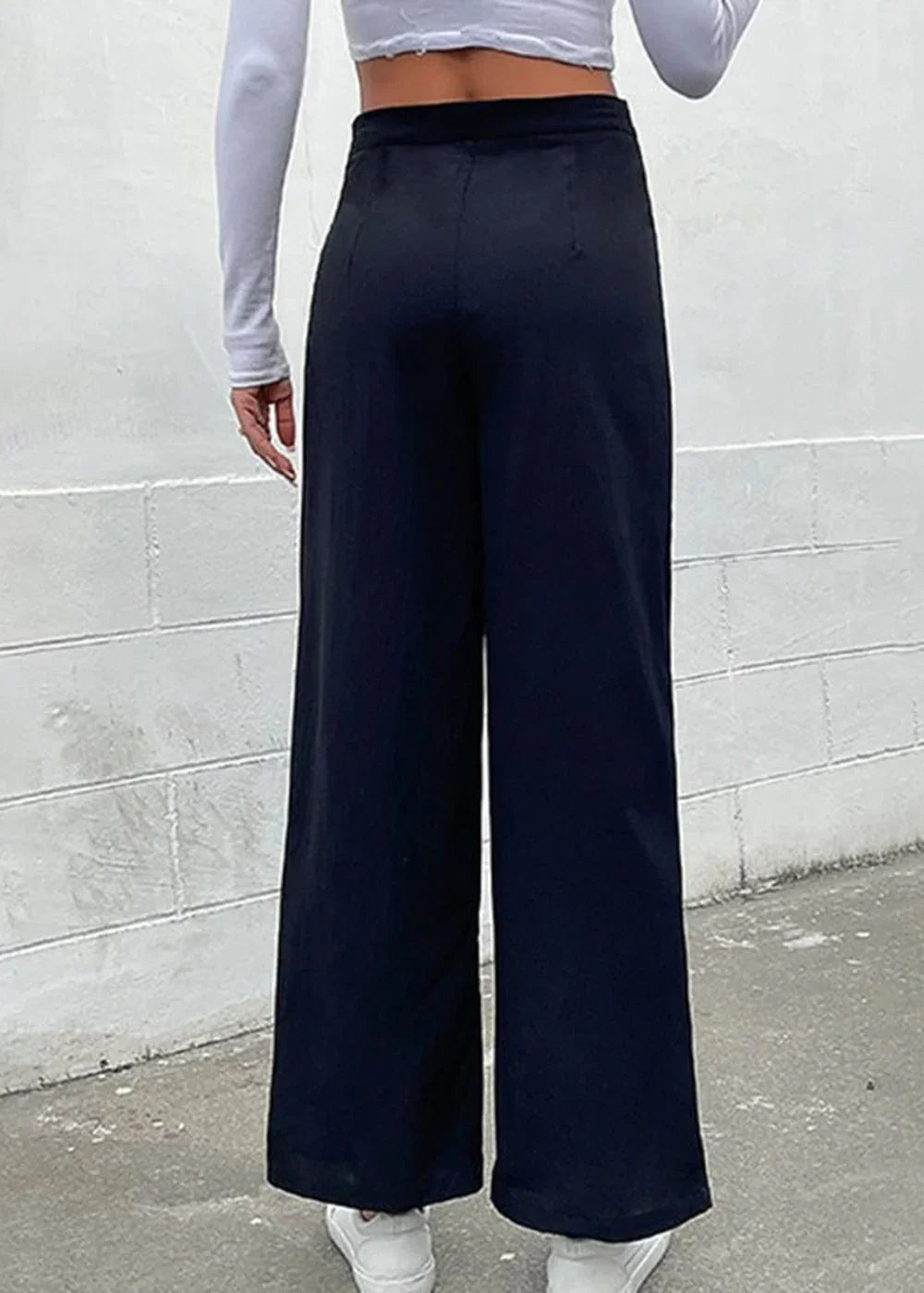 Back view of navy blue wide-leg pants with a smooth, matte texture.