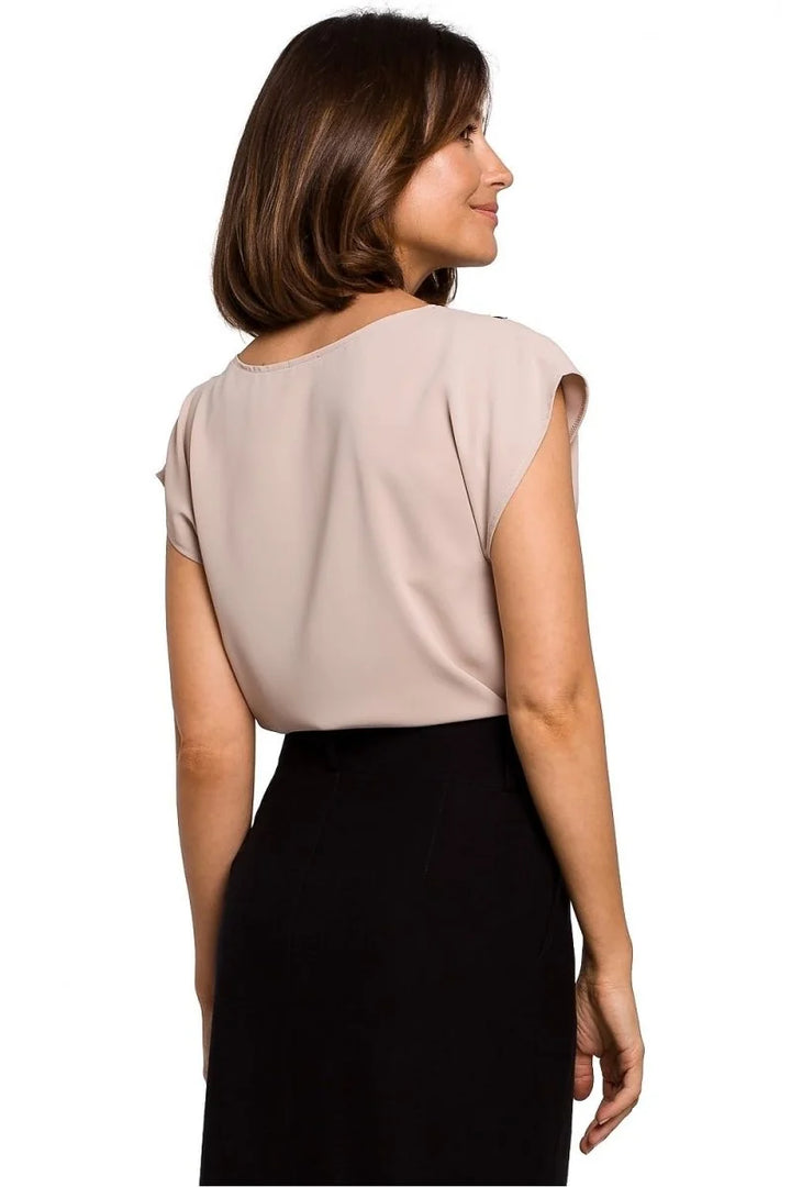 Beige short-sleeve top with black high-waisted skirt, back view.