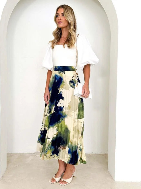Cream pleated skirt with abstract navy, green, and yellow print on model.