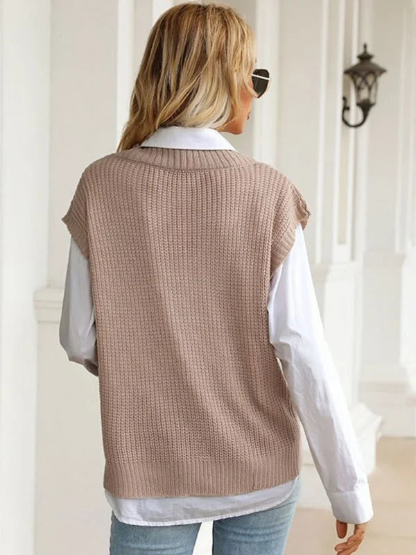 Back view of a woman wearing a beige knit vest over a white collared shirt.