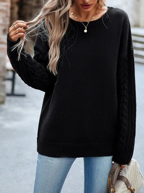 Black acrylic sweater with cable knit sleeves on model.