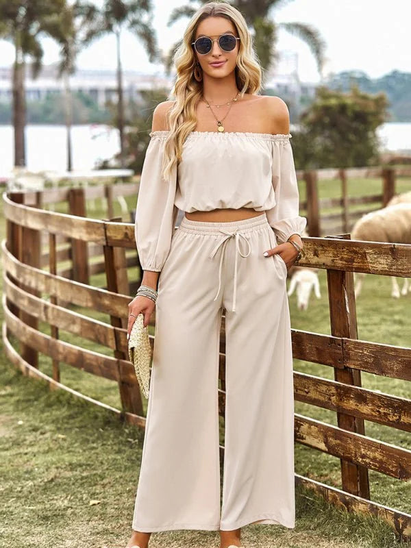 Off-the-shoulder cream crop top and matching wide-leg pants with drawstring, on model.