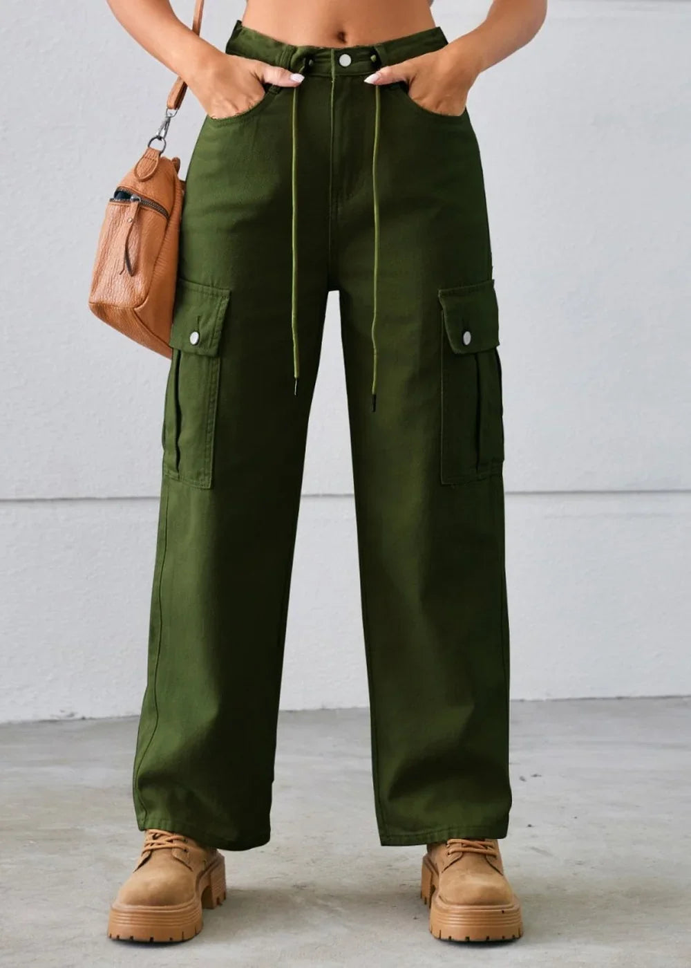Full length shot of olive green cargo pants with drawstring waist and tan platform shoes.