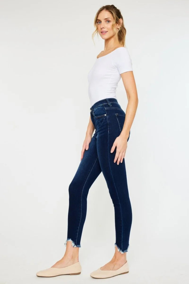 Dark wash skinny jeans with frayed hem and slightly stretchy fit on model.