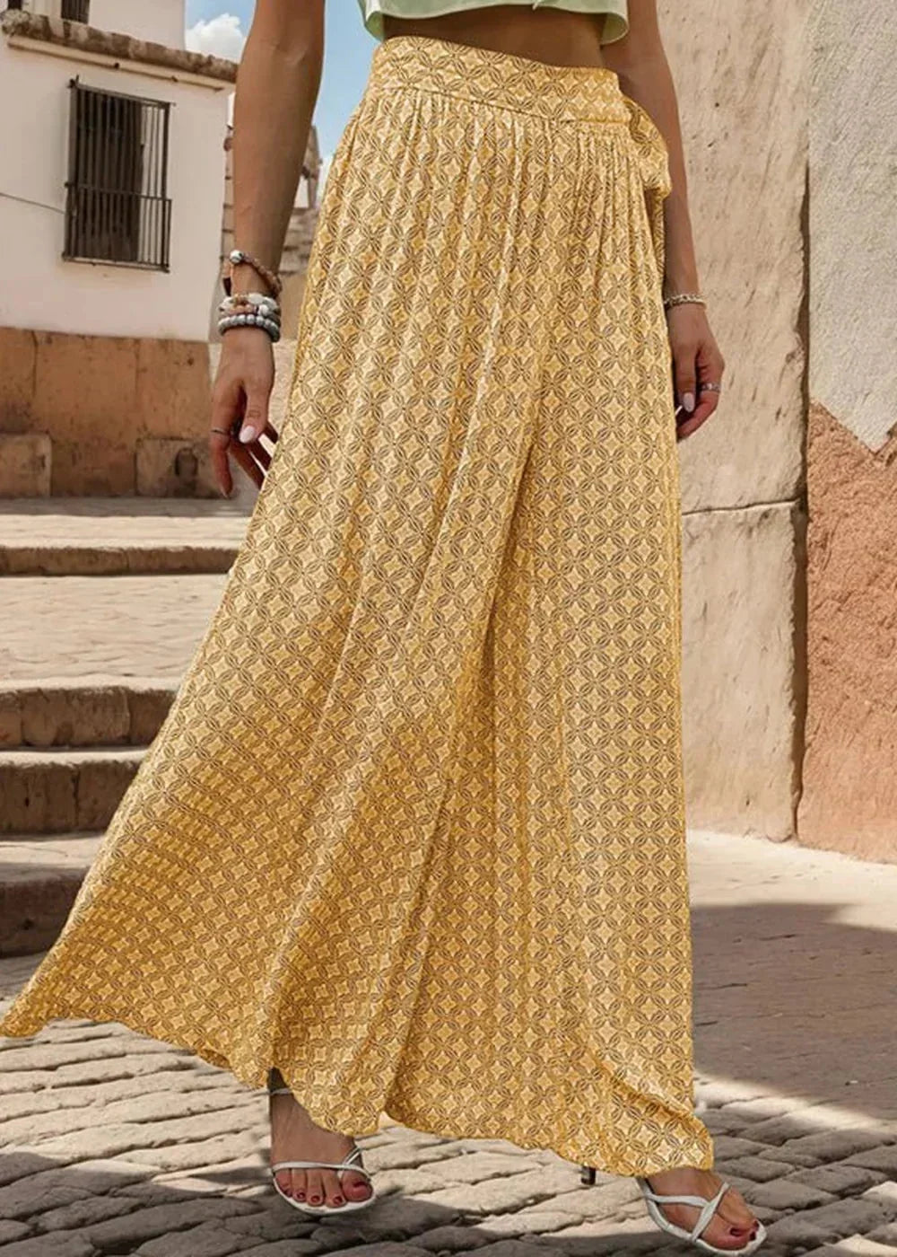 Flowy yellow wide-leg pants with a geometric print, tied at the waist.
