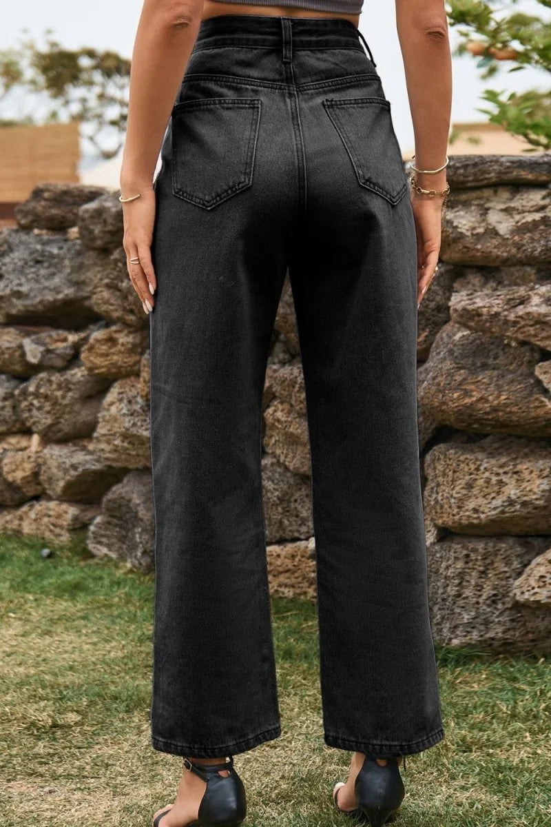 Back view of black wide-leg jeans with a distressed texture, worn with black heeled sandals.