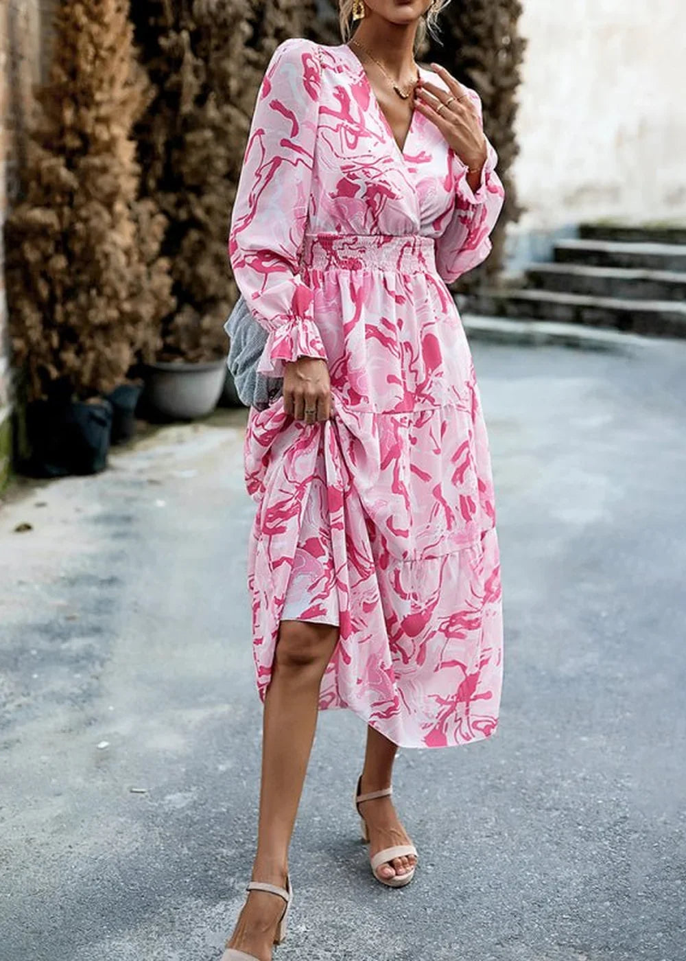 Pink abstract print maxi dress with tiered skirt and ruffled sleeves, on model.