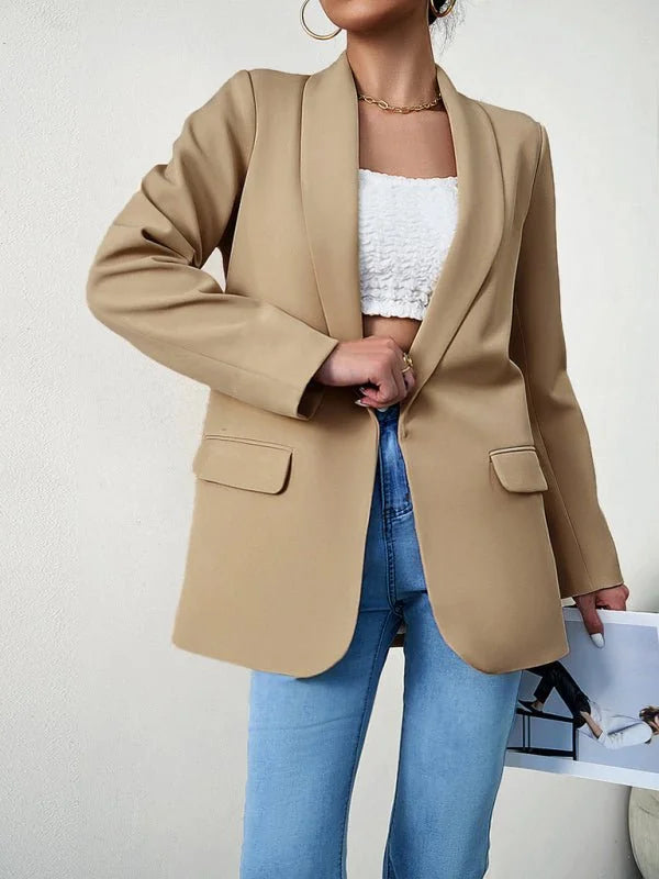 Tan lapel blazer with a textured white top and light wash jeans on a model.