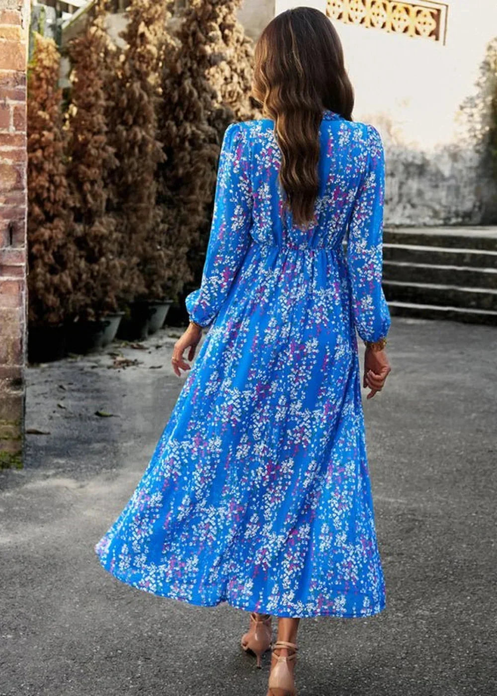 Blue floral maxi dress with long sleeves and cinched waist, seen from the back.