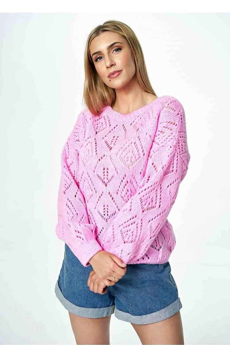 Pink open-knit sweater with a diamond pattern and cuffed denim shorts on a model.