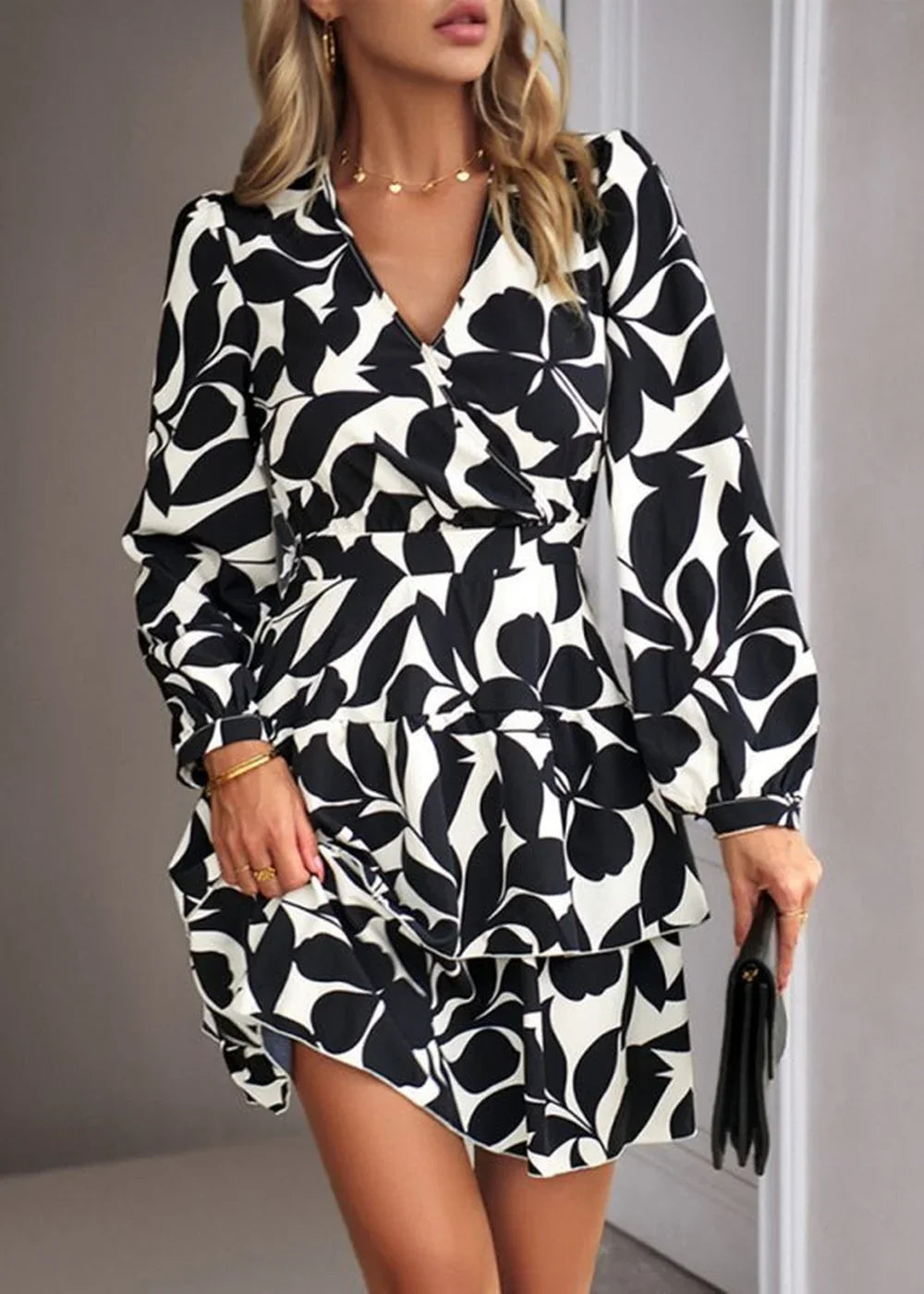 Black and white floral print wrap dress with ruffled hem on a model.