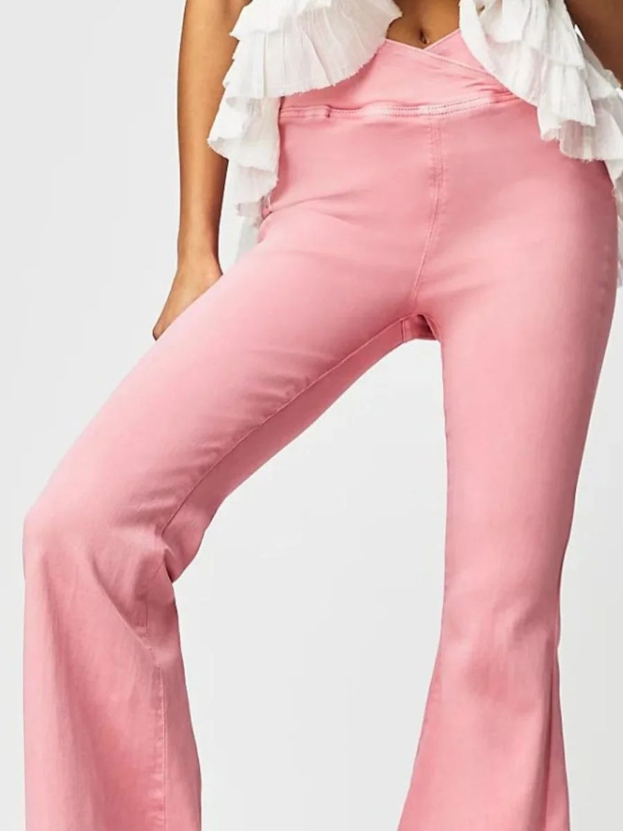 Pink flare pants with a crossover waistband and ruffled top detail.