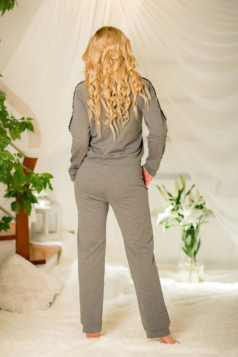 Back view of a woman wearing a gray cotton-spandex tracksuit with black trim on the sleeves.