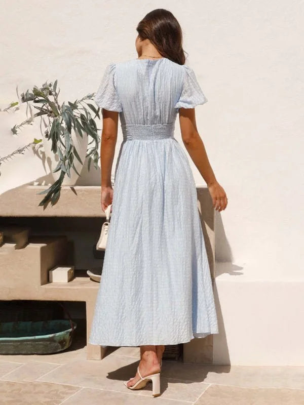 Light blue textured dress with smocked waist and puff sleeves, shown from the back.