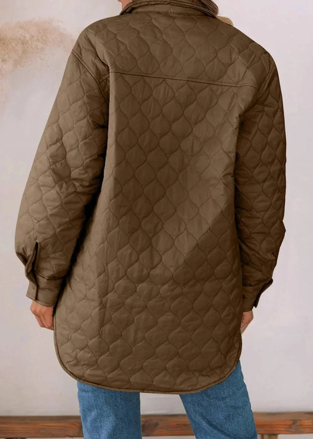 Back view of a brown quilted jacket with diamond stitching and button cuffs.