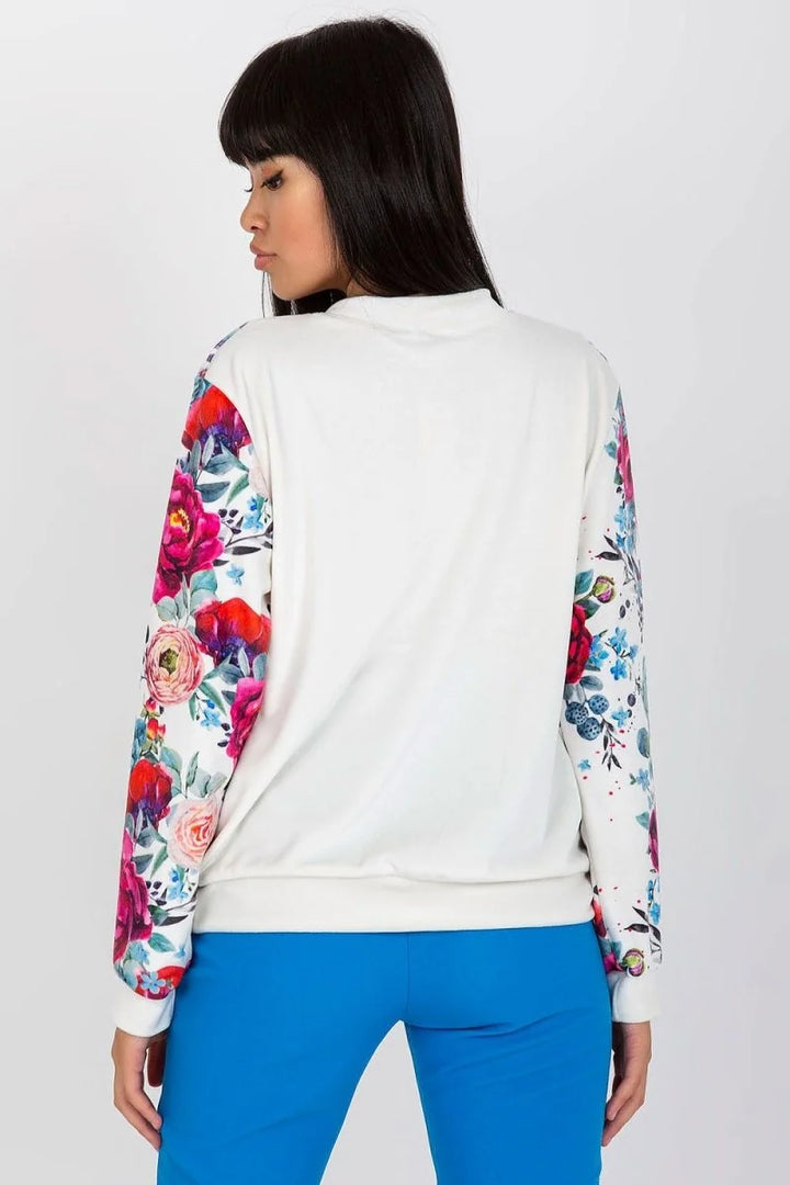 White long-sleeve top with vibrant floral print on sleeves, on model.