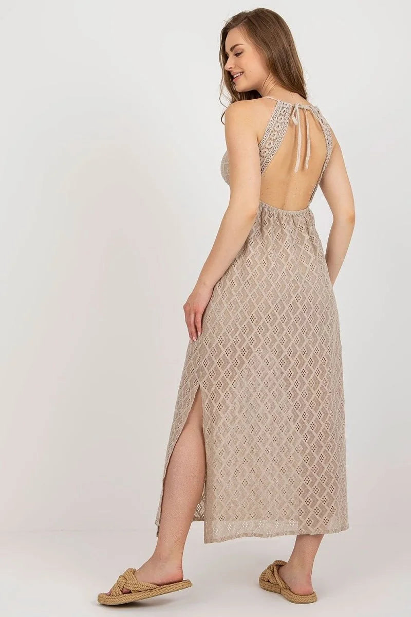 Beige crochet maxi dress with side slit and tie-back detail.