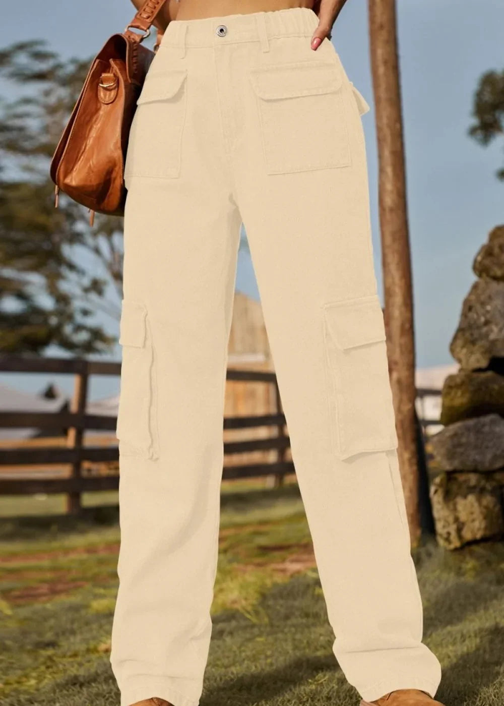 Cream-colored cargo pants with multiple pockets, shown on a model outdoors.