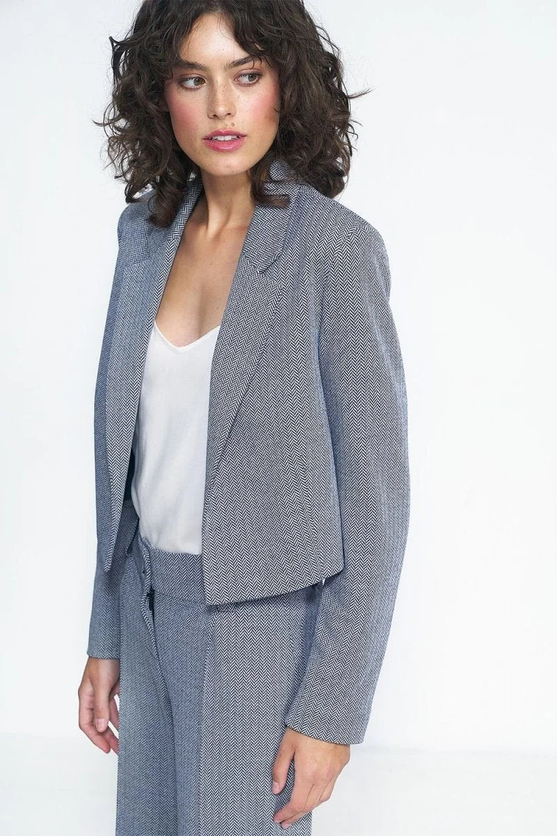 Blue and white herringbone pattern blazer with a cropped fit, worn over a white tank top.