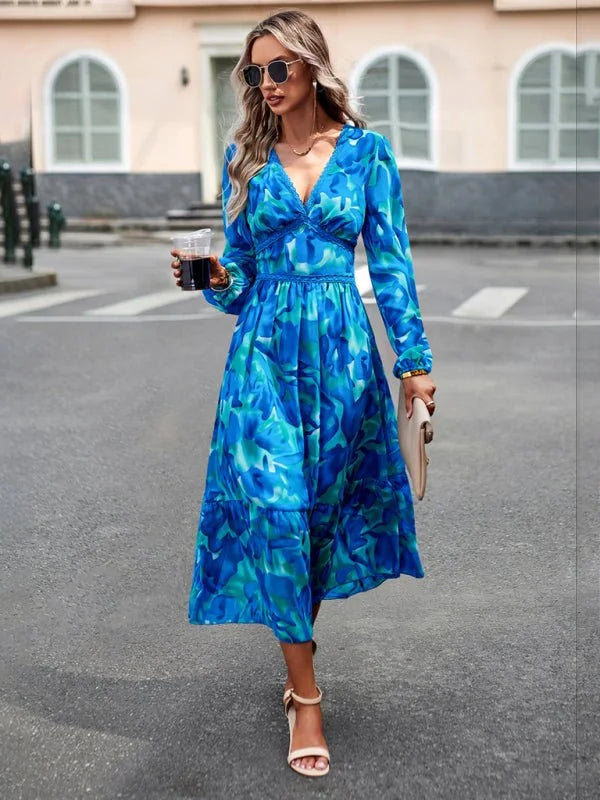 Blue and green abstract print dress with V-neck and tiered skirt, worn by a model.