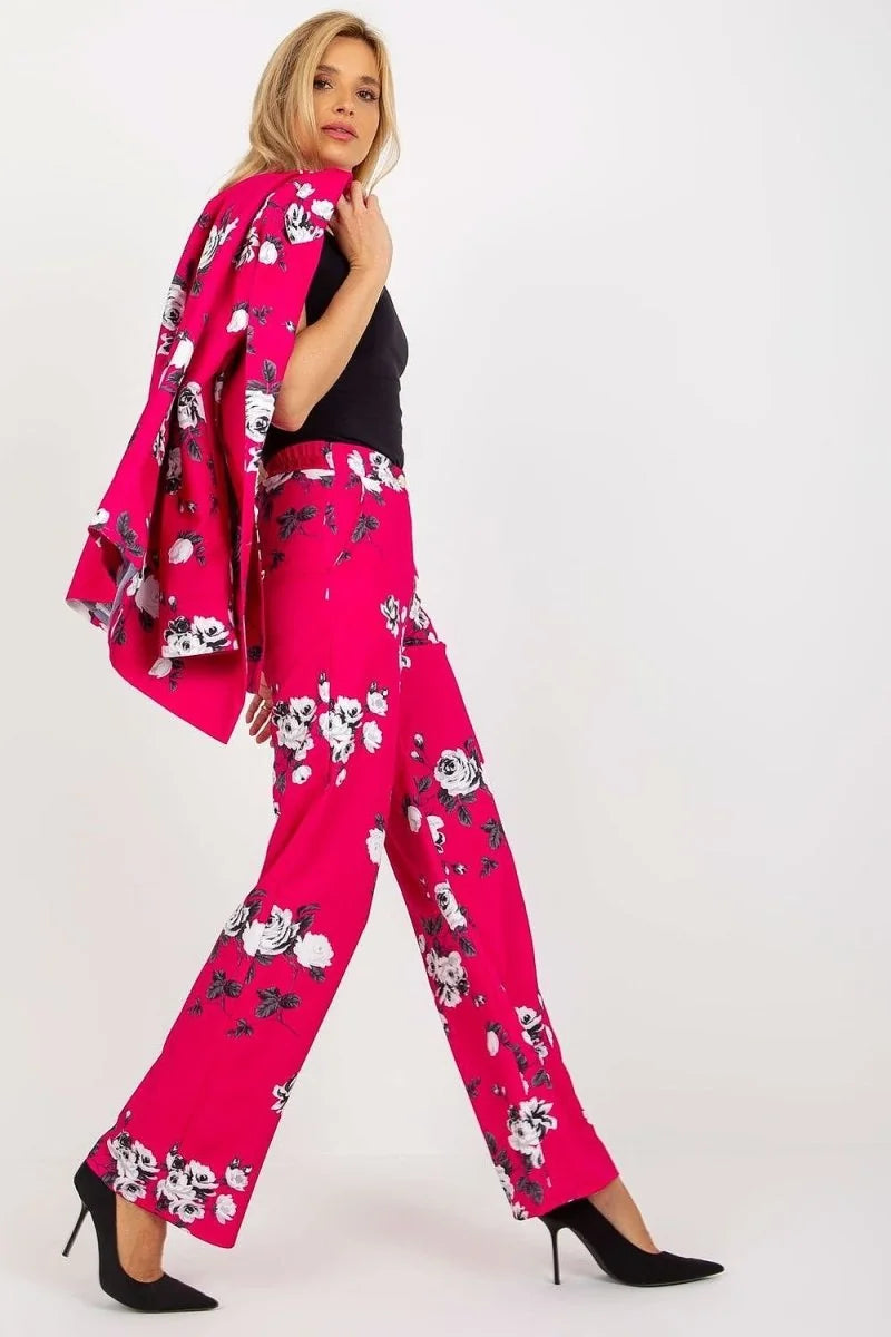 Fuchsia wide-leg pants with a white floral pattern, shown on a model with black heels.