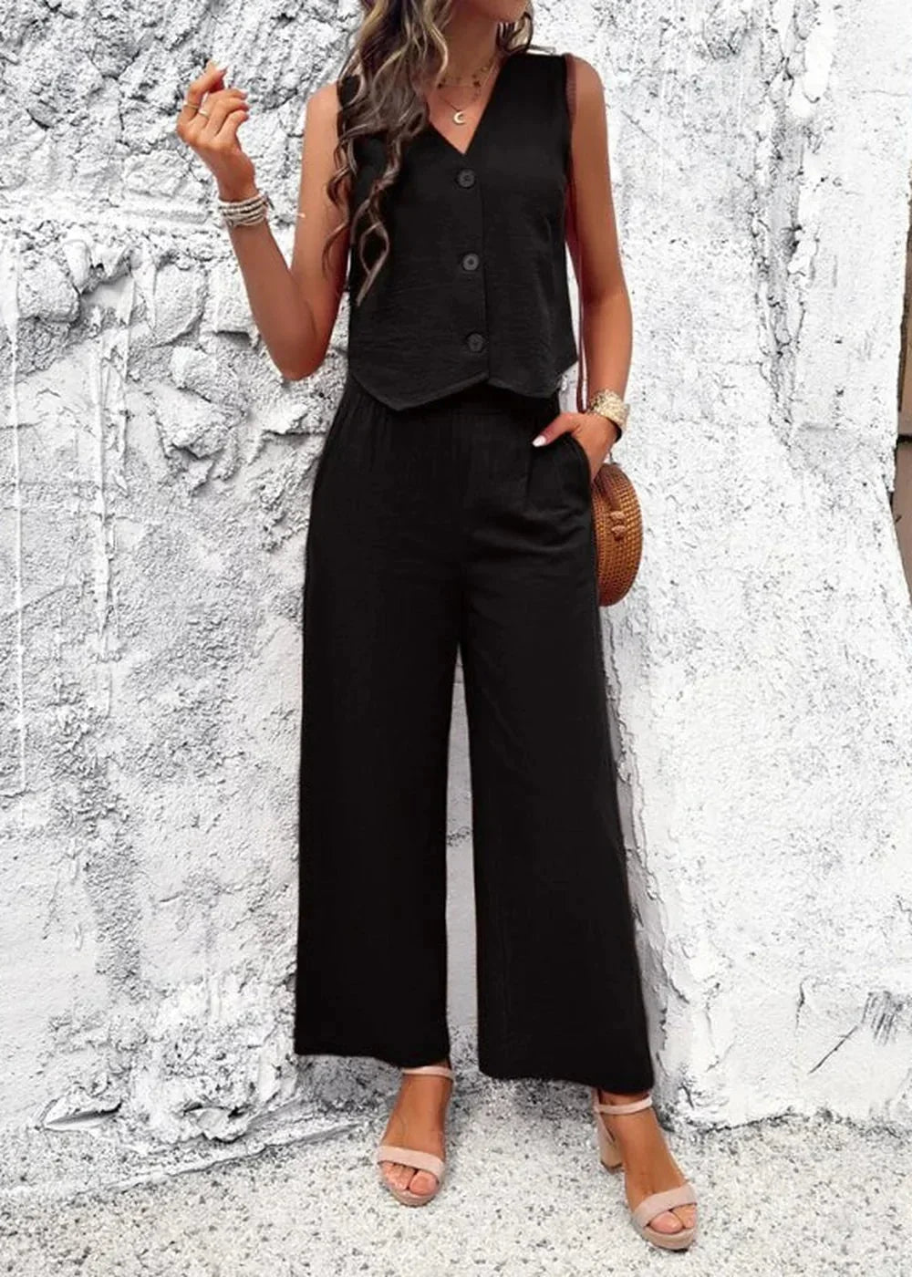 Black sleeveless v-neck vest and wide-leg pants set, made of 100% cotton, worn by a model.