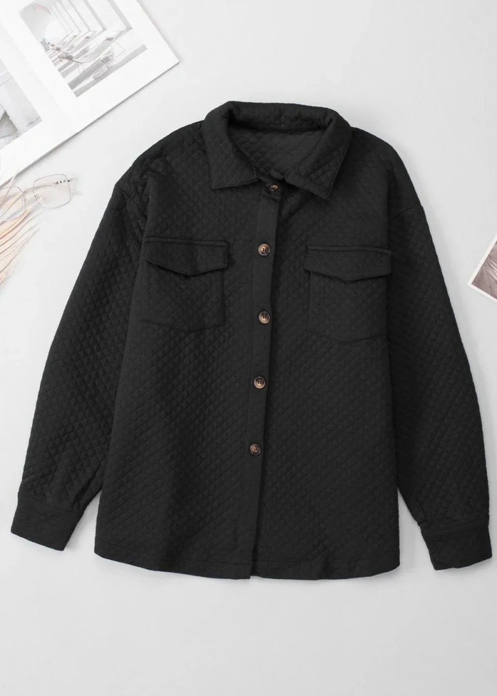 Black quilted button-down shirt jacket with chest pockets and collared neckline.